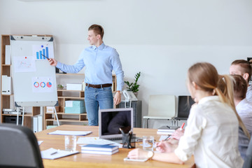 Obraz premium Young businessman giving presentation at meeting in office