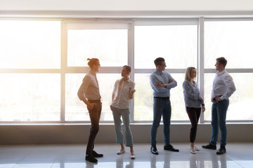 Group of young business people near window in office