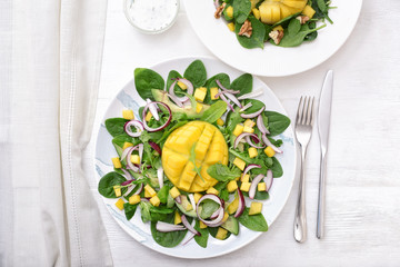 Plate with tasty mango salad on white table