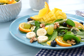 Plate with tasty mango salad on table