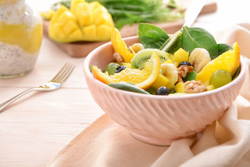Bowl with tasty mango salad on table