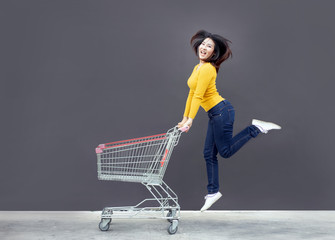 happy asian woman with shopping trolley cart