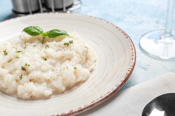 Plate with tasty risotto on table