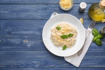 Plate with tasty risotto on wooden table