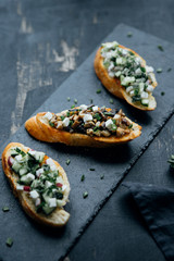 Different bruschetta on black board