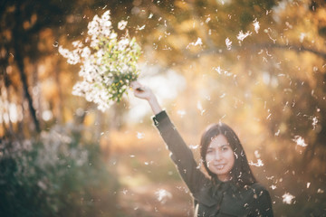 Dreamy beautiful girl in white fluff on bokeh background with yellow leaves in golden sunlight....