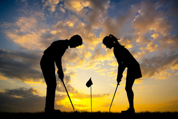 man teaches woman to play golf