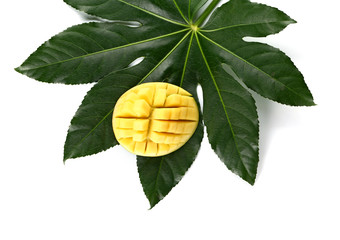 Tasty fresh mango with tropical leaf on white background
