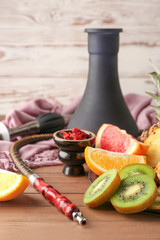 Hookah with tobacco and fresh fruits on table