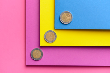 Paper sheets with coins on color background