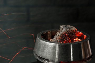 Burning coal for hookah on dark background