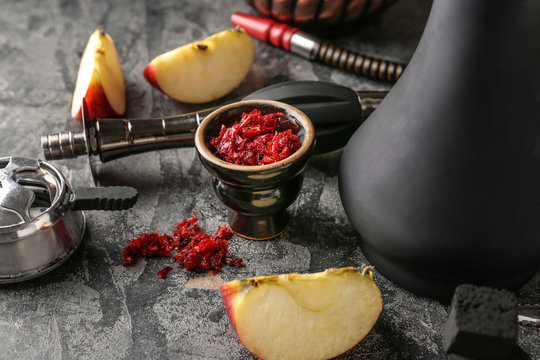 Hookah with tobacco and fresh apple on grey table