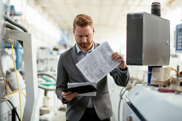 Portrait of attractive ginger businessman in factory