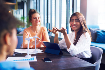 Young adult coworkers having a conversation at office table