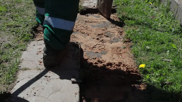 worker makes repair of the walkway at home.