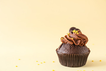Tasty chocolate cupcake on light background