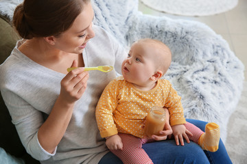 Mother feeding her little baby at home