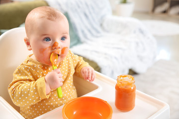 Cute little baby eating tasty food at home