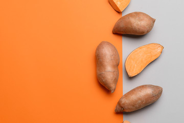 Fresh sweet potatoes on color background