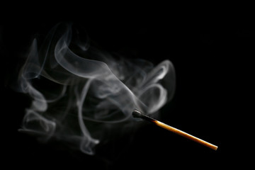Burnt out match on dark background