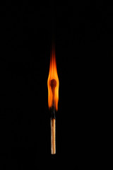 Burning match on dark background