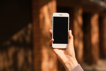 Young woman with mobile phone outdoors