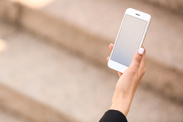 Young woman with mobile phone outdoors