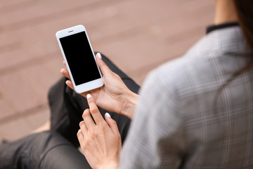 Young woman with mobile phone outdoors