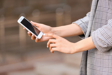 Young businesswoman with mobile phone outdoors