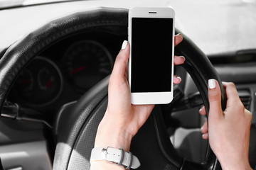 Young woman with mobile phone in car, closeup