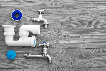 Set of plumber tools on wooden background