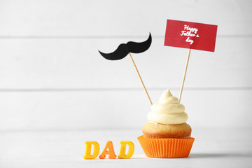 Tasty cupcake for Father's Day on white background