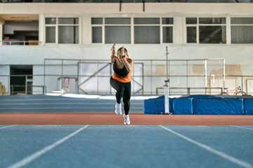 Sportive blonde woman training at indoor stadium