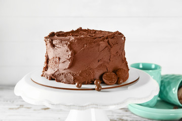 Stand with tasty chocolate cake on table