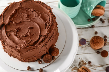 Stand with tasty chocolate cake on table