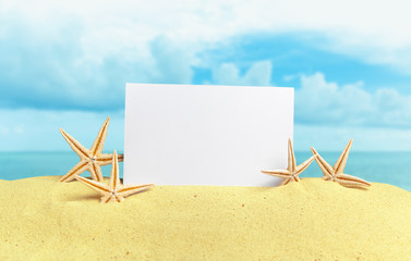 Fototapeta na wymiar Seashells with blank card on sand beach