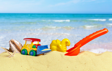 Fototapeta na wymiar colorful toys for child sandboxes against the beach sand background