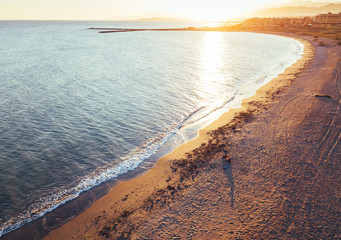 Aerial views of a girl with her dog at a virgin beach, in Natural park Punta Entinas, Almeria, Spain