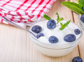  Jogurt z jagodami. Czarne jagody w misce podane na sniadanie. Musli z owocami, swieze owoce.  Zdrowe i pozywne sniadanie. © ff25