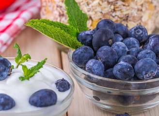  Jogurt z jagodami. Czarne jagody w misce podane na sniadanie. Musli z owocami, swieze owoce.  Zdrowe i pozywne sniadanie. © ff25