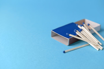 Box with matches on color background