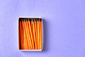 Box with matches on color background