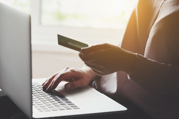 young man using laptop and holding credit card, online shopping concept