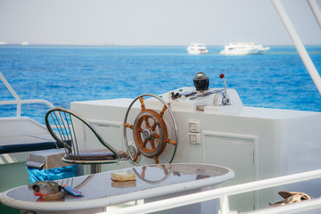 The yacht's steering wheel at sea background.
