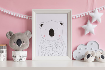 The modern scandinavian newborn baby room with mock up poster frame, koala bear, white basket, stars and children accessories. Cozy interior with pink walls. Haniging cotton garland and stars. 