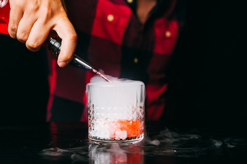 Barman making red smoking cocktail