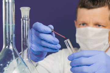 At the lab. Low angle selective focus close up shot of a senior scientist in a mask holding a rack...