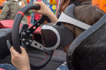 Child wearing VR glasses driving a car