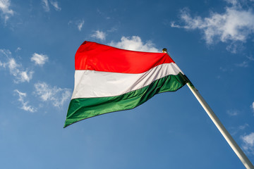 Hungarian hungary national red white green flag in the wind over blue coludy sky