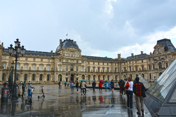 Obraz premium PARIS, FRANCE - MAY 25, 2019: Famous Paris Louvre. People in main courtyard (Cour Napoleon) 